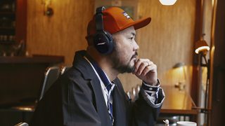 カフェでQC35 IIミッドナイトブルーを着ける山根敏史