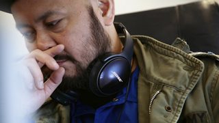 機内でQC35 IIを首にかける山根敏史