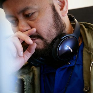 飛行機内で首にQC35 IIをかける山根敏史
