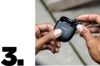 Person removing a QC Earbud II from the charging case