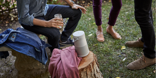 Tragbarer Bose Lautsprecher auf einem Tisch beim Grillen im Garten