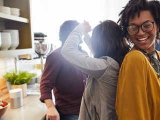 Friends partying in a kitchen listening to a Bose Home Speaker 300