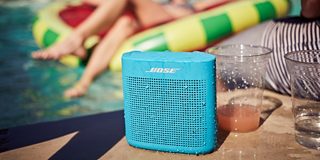 SoundLink Color Bluetooth speaker II mit Wassertropfen neben einem Pool