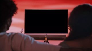 Coppia che guarda la TV con una soundbar smart Bose Ultra