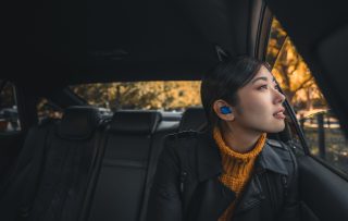 Femme dans une voiture portant les écouteurs pour le sport Bose