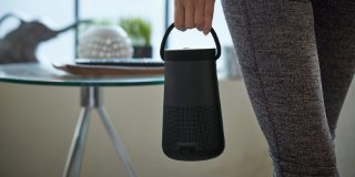 Woman carrying a SoundLink Revolve+ II Bluetooth speaker