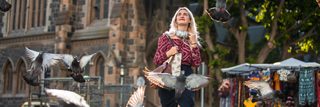 Woman walking outside with Bose Noise Cancelling Headphones 700 around her neck