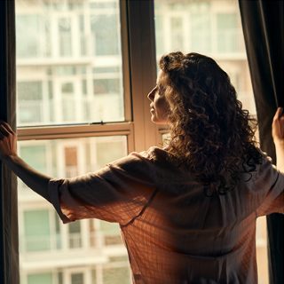 Mujer abriendo cortinas