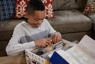 Boy looking at the parts of the BOSEbuild Speaker Cube