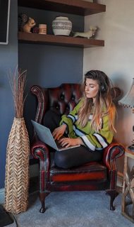 Woman wearing Bose QuietComfort 45 Headphones while working on her laptop