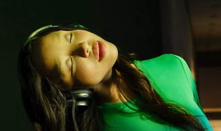 Femme fermant les yeux et écoutant de la musique avec le casque Bose QuietComfort Ultra