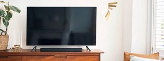 Bose Smart Soundbar 300 y una televisión en una consola de TV