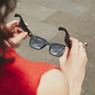 Woman holding Bose Frames Alto - best travel gifts
