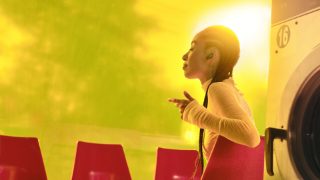 Woman sitting in a chair wearing Bose QuietComfort Ultra Earbuds