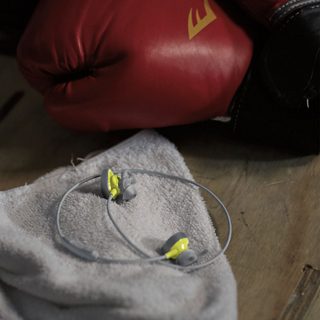 Audífonos inalámbricos SoundSport en una toalla junto a un guante de boxeo