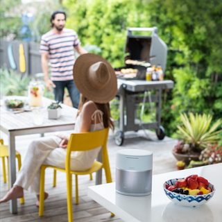 Enceinte Bose Home Speaker 300 sur une table en extérieur