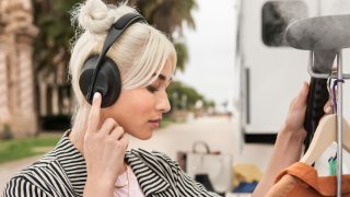 Woman wearing Bose Noise Cancelling Headphones 700 using the touch controls