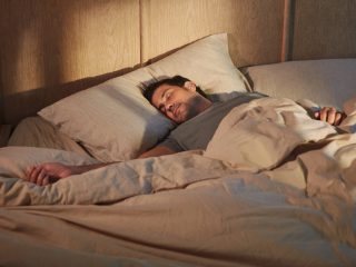 Man som sover med Bose Sleepbuds II