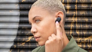 Người phụ nữ sử dụng điều khiển cảm ứng của Bose QuietComfort Earbuds