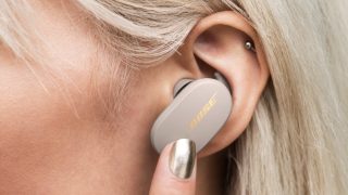 Woman double-tapping the left earbud to adjust the noise cancellation level of the Bose QuietComfort Earbuds