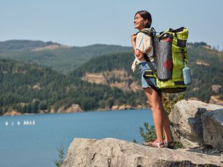 Woman hiking with a SoundLink Flex Bluetooth speaker attached to her backpack