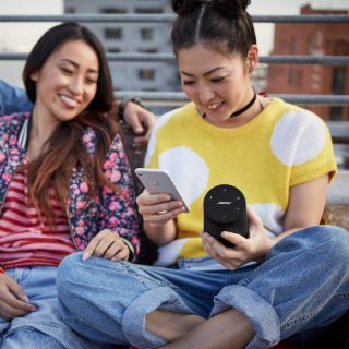 2 women listening to music on a SoundLink Revolve II Bluetooth speaker