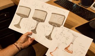 Mark Jupiter sitting at a desk holding sketches of the 901 Speaker.