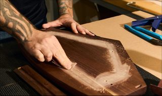 Man sanding the casing of the 901 Speaker.