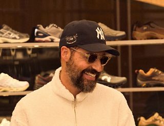 Ronnie Fieg standing in front of a display of trainers.