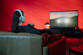 Donna che guarda un film con audio spaziale utilizzando le cuffie Bose QuietComfort Ultra
