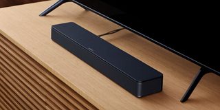 Mit dem Fernseher verbundener Bose TV-Lautsprecher, der auf einem TV-Ständer steht