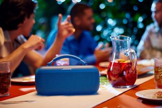 Diffusore portatile Bose SoundLink Max che riproduce musica su un tavolo durante un barbecue all’esterno