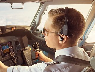 Commercial pilot in a cockpit wearing a ProFlight Series 2 Aviation Headset