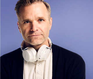 Ben Gibbard with Bose QuietComfort Ultra Headphones around his neck.