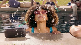 Kobieta w stroju kąpielowym słuchająca muzyki z głośnika SoundLink Flex Bluetooth Speaker marki Bose 