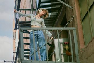 Женщина в наушниках Bose QuietComfort на пожарной лестнице