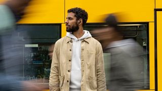 Man wearing QuietComfort Earbuds II out on a city street