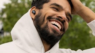 在外面打電話時戴著 QuietComfort Earbuds II 的男人