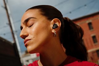 戶外戴著 Bose QuietComfort 消噪耳塞 Ultra （第 2 代）的女子。