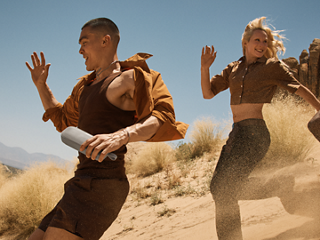 Friends running on sand dunes listening to a Bose SoundLink Flex Portable Speaker (2nd Gen).