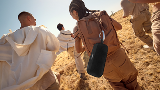 Friends walking outside listening to a Bose SoundLink Flex Portable Speaker (2nd Gen).