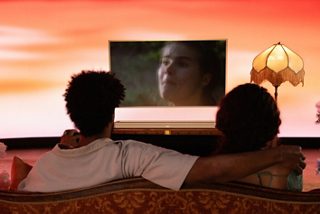一對情侶正使用 Bose Ultra 智能揚聲器觀看電視節目