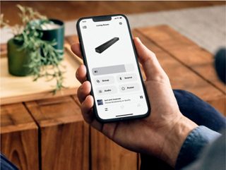 Man using the Bose App for the Bose Smart Soundbar on a smartphone.
