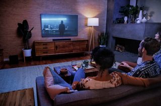 Pareja mirando televisión en una sala de estar con una Bose Smart Soundbar 600