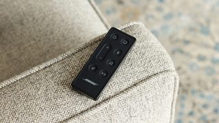 Bose Smart Soundbar 600 remote on the arm of a couch
