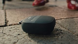 Bose SoundLink Micro 便攜式揚聲器(第 2 代)放在戶外地上。