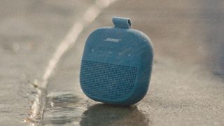 Bose SoundLink Micro 便攜式揚聲器(第 2 代)於陽光照耀下放在地上。