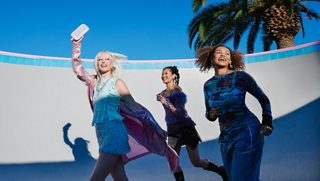 3 women walking outside with one of them holding a Chilled Lilac SoundLink Flex Bluetooth Speaker in the air