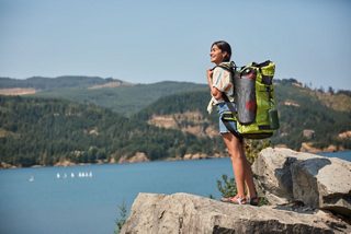 Woman hiking with a Cypress Green SoundLink Flex Bluetooth Speaker attached to her backpack